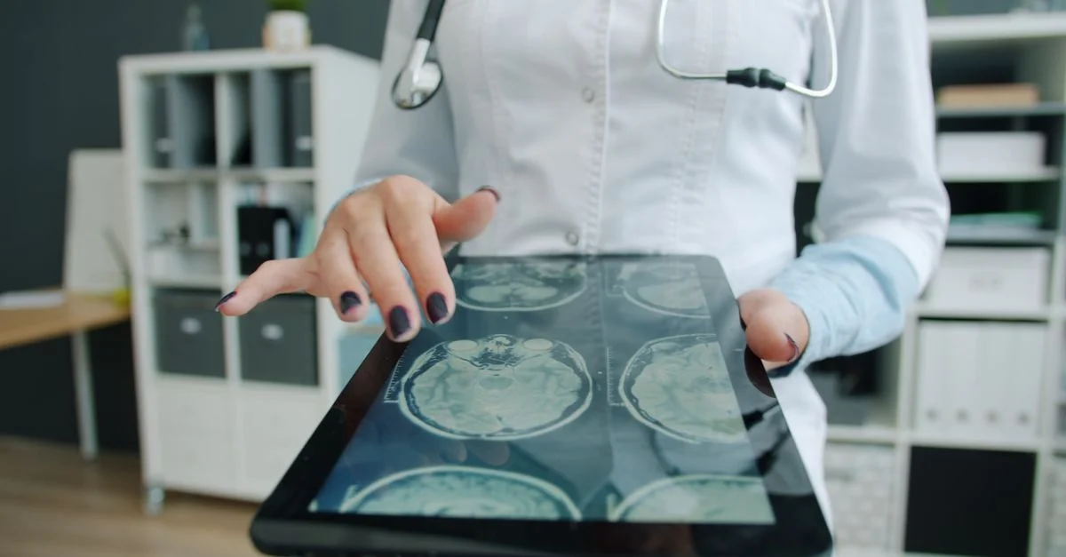 Un médecin examine des images numériques du cerveau sur une tablette dans un cabinet médical.