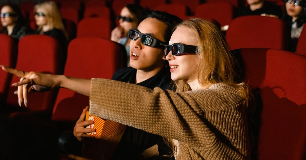 Un couple portant des lunettes 3D profite d'un film au cinéma, immergé dans l'expérience.