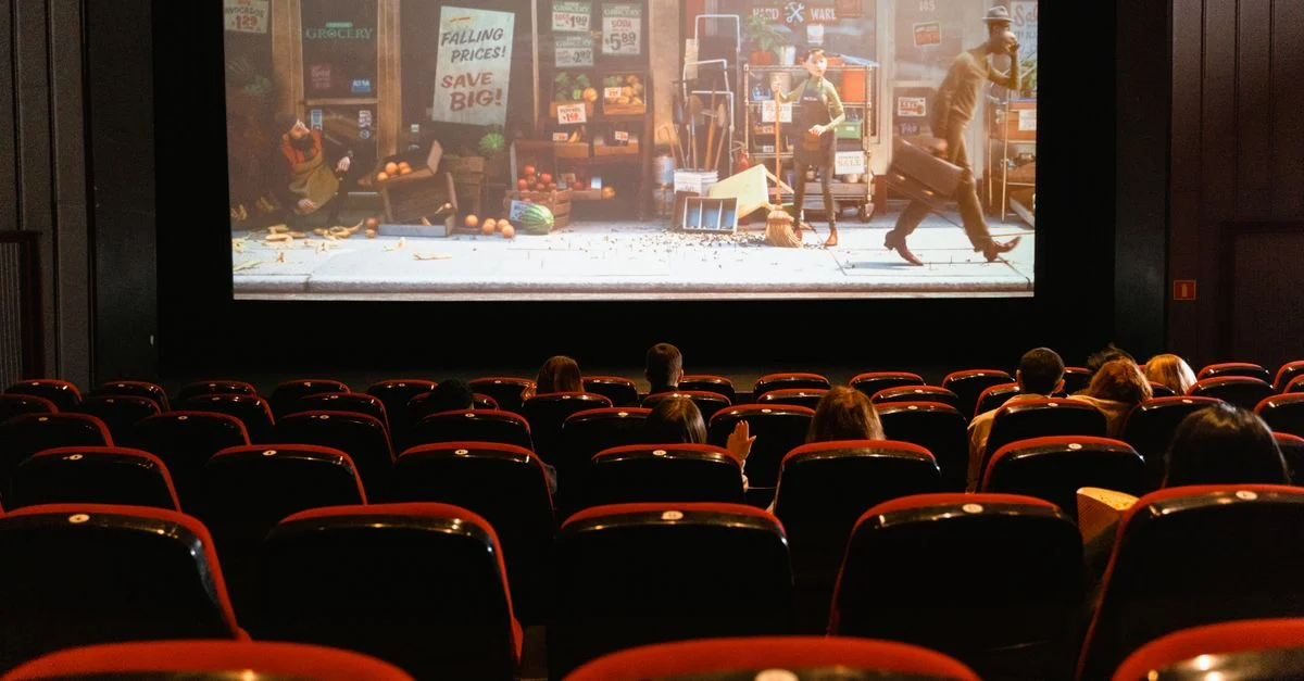 Un cinéma intérieur chaleureux projetant un film d'animation à un petit public.